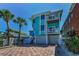 Beautiful turquoise beach house featuring multiple balconies and a two-car garage at 13303 Gulf Ln, Madeira Beach, FL 33708