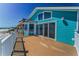 Exterior of a coastal home with a large deck overlooking the ocean and beach at 13303 Gulf Ln, Madeira Beach, FL 33708