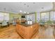 A chef's kitchen with hardwood floors, a center island, and open concept dining and living areas at 13303 Gulf Ln, Madeira Beach, FL 33708