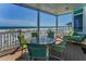 Outdoor patio seating overlooking a beautiful ocean and sandy beach on a sunny day at 13303 Gulf Ln, Madeira Beach, FL 33708