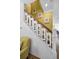 Unique staircase with decorative spindles and wood railing complemented by beach-themed art at 13303 Gulf Ln, Madeira Beach, FL 33708