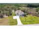 An aerial shot of a beautiful single-Gathering home with an oversized driveway, a vast lawn, and surrounded by lush trees at 13334 Oldenburg Dr, Hudson, FL 34667
