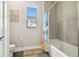 Well-lit bathroom with a tub, modern shower curtain, wood-look flooring, and a window providing natural light at 13334 Oldenburg Dr, Hudson, FL 34667