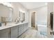 Modern bathroom with double vanity, marble countertop, and soaking tub for a spa-like experience at 13334 Oldenburg Dr, Hudson, FL 34667