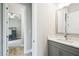 Modern bathroom vanity featuring a gray cabinet, white countertops, and an open doorway leading to a bedroom at 13334 Oldenburg Dr, Hudson, FL 34667