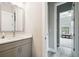 Modern bathroom vanity featuring a gray cabinet, white countertops, and an open doorway leading to a bedroom at 13334 Oldenburg Dr, Hudson, FL 34667