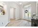 Bright foyer features wood flooring, a modern chandelier, and a welcoming entrance at 13334 Oldenburg Dr, Hudson, FL 34667