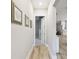 A pristine hallway featuring light wood flooring, leading to a view of the kitchen at 13334 Oldenburg Dr, Hudson, FL 34667