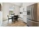 Bright kitchen with a stainless steel refrigerator, dining nook, and white cabinets at 13334 Oldenburg Dr, Hudson, FL 34667