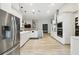 Spacious open kitchen featuring stainless steel appliances, white cabinetry, and wood look flooring at 13334 Oldenburg Dr, Hudson, FL 34667