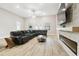 Open-concept living room featuring a cozy sectional sofa, stone fireplace, and modern decor at 13334 Oldenburg Dr, Hudson, FL 34667