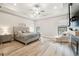 Relaxing main bedroom with a tray ceiling, wood-look flooring, and comfortable seating area at 13334 Oldenburg Dr, Hudson, FL 34667