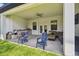 Covered outdoor patio featuring an outdoor kitchen, seating area, and access to the backyard at 13334 Oldenburg Dr, Hudson, FL 34667