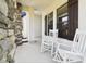 Inviting porch with white rocking chairs, stone accents, and a relaxing atmosphere at 13334 Oldenburg Dr, Hudson, FL 34667