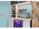 Stylish bar with wine storage, mini fridge, accent lighting, and decorative stone wall at 13810 Lake Village Pl, Tampa, FL 33618