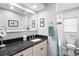 Bathroom featuring a large mirror, white vanity, black countertop, and walk-in shower at 13810 Lake Village Pl, Tampa, FL 33618