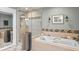 Elegant bathroom featuring a luxurious soaking tub and a separate glass-enclosed shower at 13810 Lake Village Pl, Tampa, FL 33618