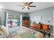 Comfortable bedroom with ceiling fan and sliding glass door to screened lanai and pool at 13810 Lake Village Pl, Tampa, FL 33618
