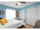 Comfortable bedroom featuring light blue walls, wood floors, and natural lighting at 13810 Lake Village Pl, Tampa, FL 33618