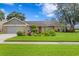 Ranch style home with stone accents, mature landscaping in the front yard and a two car garage at 13810 Lake Village Pl, Tampa, FL 33618