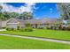 Charming single-story home features beautiful landscaping, a well-maintained lawn, and stone accents at 13810 Lake Village Pl, Tampa, FL 33618