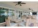 Relaxing covered patio featuring a ceiling fan, a dining table with seating, and sliding glass doors to the interior at 13810 Lake Village Pl, Tampa, FL 33618