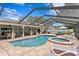 Inviting screened pool and spa area with ample seating and dining spaces for outdoor enjoyment at 13810 Lake Village Pl, Tampa, FL 33618