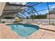 Enclosed backyard pool with integrated hot tub and various lounge areas with chairs and side tables on a brick deck at 13810 Lake Village Pl, Tampa, FL 33618