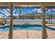 Beautiful screened-in pool and spa surrounded by a brick patio with lounge chairs and shade at 13810 Lake Village Pl, Tampa, FL 33618