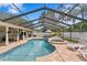 A screened-in pool with hot tub and plenty of seating with a covered lanai providing shade and comfort at 13810 Lake Village Pl, Tampa, FL 33618