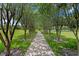 Shaded walking path lined with trees, providing a serene and scenic route for exercise and recreation at 13810 Lake Village Pl, Tampa, FL 33618
