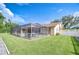 Expansive backyard with a screened-in pool, patio furniture, and well-manicured lawn at 13903 Wolcott Dr, Tampa, FL 33624