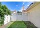 Backyard features a white privacy fence, green grass, gate and tropical foliage at 13903 Wolcott Dr, Tampa, FL 33624
