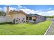 A spacious backyard featuring a screened-in pool area with lush greenery and well-maintained lawn at 13903 Wolcott Dr, Tampa, FL 33624