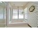 Bright bathroom featuring a shower, tub, and window providing natural light at 13903 Wolcott Dr, Tampa, FL 33624