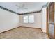 Bedroom with neutral carpet, wallpaper border and louvered closet doors at 13903 Wolcott Dr, Tampa, FL 33624