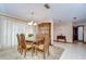 Dining room with a classic wooden table set for six, illuminated by a chandelier at 13903 Wolcott Dr, Tampa, FL 33624