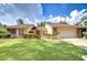 Well-manicured lawn and mature landscaping complement this charming single-Gathering home at 13903 Wolcott Dr, Tampa, FL 33624