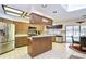 Bright kitchen featuring wooden cabinetry, stainless steel appliances, and a breakfast bar overlooking the pool at 13903 Wolcott Dr, Tampa, FL 33624