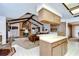 Open-concept living space featuring exposed wood beams, a brick fireplace and seamless integration with the adjacent kitchen at 13903 Wolcott Dr, Tampa, FL 33624