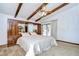 Bright main bedroom featuring exposed beams, ceiling fan, and built-in wardrobe at 13903 Wolcott Dr, Tampa, FL 33624