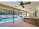 Covered pool area with brick flooring, a built-in bar, and seating areas perfect for outdoor entertaining at 13903 Wolcott Dr, Tampa, FL 33624