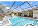 Screened pool area surrounded by brick pavers, landscaping, and an outdoor bar area at 13903 Wolcott Dr, Tampa, FL 33624