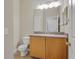 Bathroom featuring oak vanity, neutral paint, updated lighting, and a toilet at 16137 Churchview Dr, Lithia, FL 33547