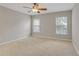 Bedroom with carpet and ceiling fan featuring two windows overlooking the yard at 16137 Churchview Dr, Lithia, FL 33547