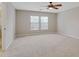 Spacious bedroom featuring two windows and neutral carpet and ceiling fan at 16137 Churchview Dr, Lithia, FL 33547