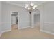 Dining room showing a neutral color palette and chandelier and doorway leading to kitchen at 16137 Churchview Dr, Lithia, FL 33547