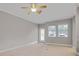 Neutral living room featuring carpeted floor, ceiling fan, and natural light from the front door and two windows at 16137 Churchview Dr, Lithia, FL 33547