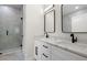 Bright bathroom featuring double sinks, modern fixtures, and a glass-enclosed shower with marble-look tile at 1625 39Th S St, St Petersburg, FL 33711