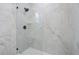 Modern shower features marble look tile surround, glass door, black fixtures and a built in shelf at 1625 39Th S St, St Petersburg, FL 33711